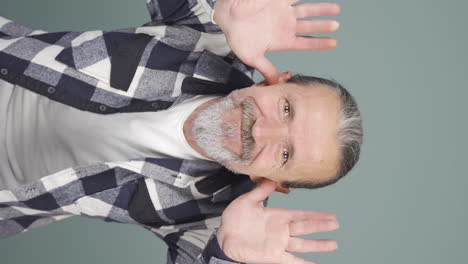 Vertical-video-of-The-old-man-making-cute-gestures-for-the-camera.